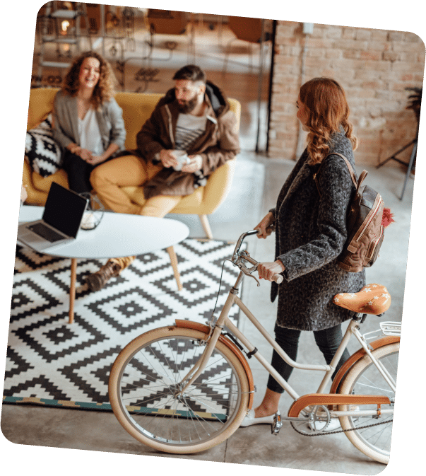 Femme qui rentre avec son vélo dans un espace de coworking